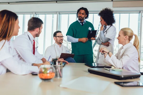 Medical team sitting and discussing at the table in the office. — Stock Photo, Image