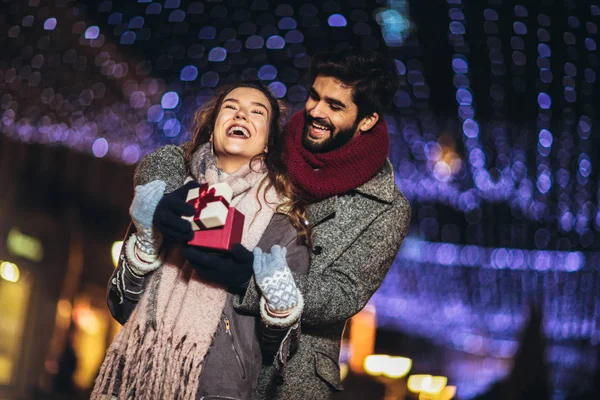 Young couple in the city centre with holiday's brights in backgr — Stock Photo, Image