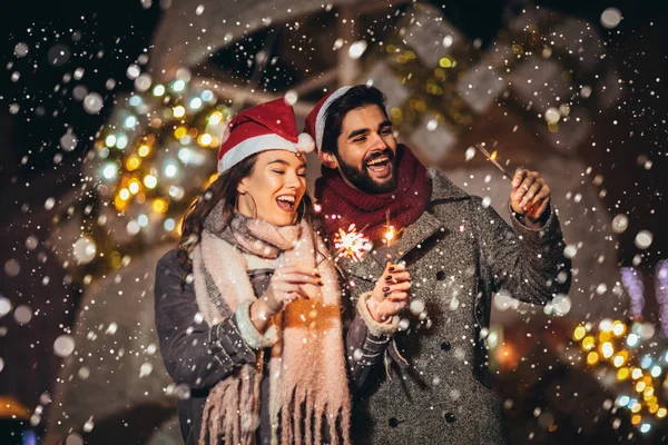 Jong liefhebbend paar branden sterren door vakantie verlichting op — Stockfoto