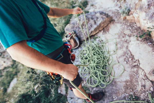 Close-up de alpinista com equipamento de escalada, amarrando nó na subida — Fotografia de Stock