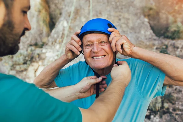 Senior klimmer met klimuitrusting, voorbereiding op het klimmen. — Stockfoto