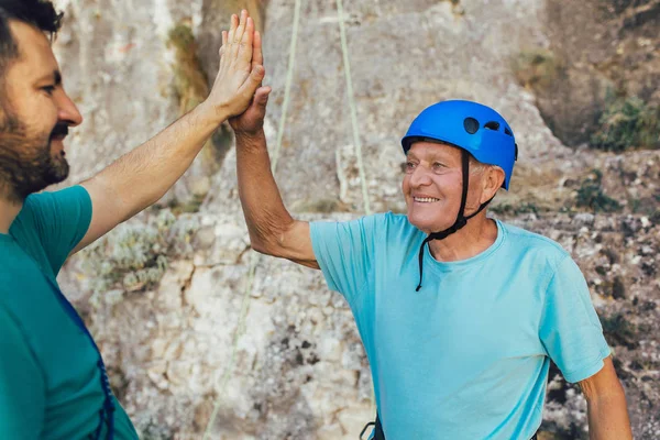 Escalador senior con equipo de escalada, preparándose para escalar . — Foto de Stock