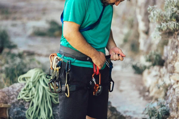 Close-up de alpinista com equipamento de escalada, amarrando nó na subida — Fotografia de Stock