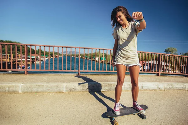 Jovem mulher esportiva montando no skate na estrada. — Fotografia de Stock