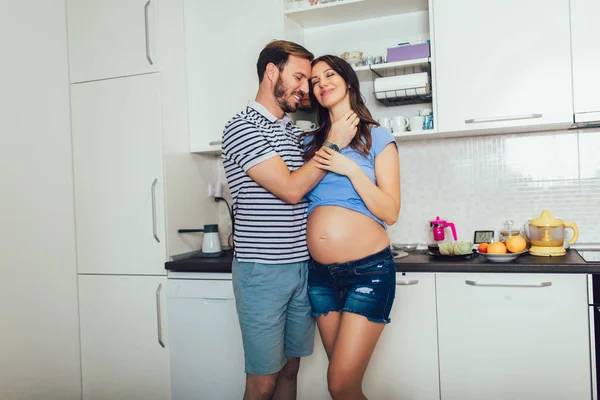 Mulher grávida com marido na cozinha — Fotografia de Stock