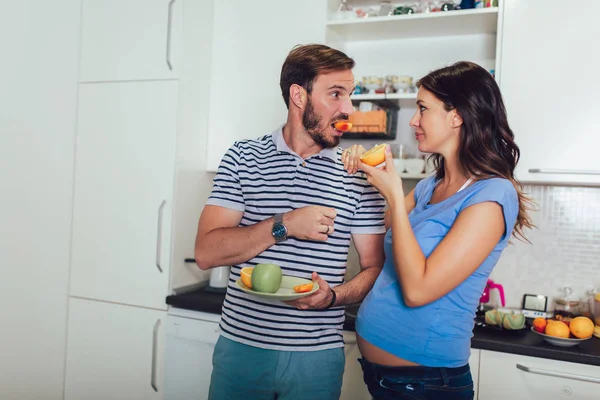 Pregnant woman with husband in the kitchen — Stock Photo, Image