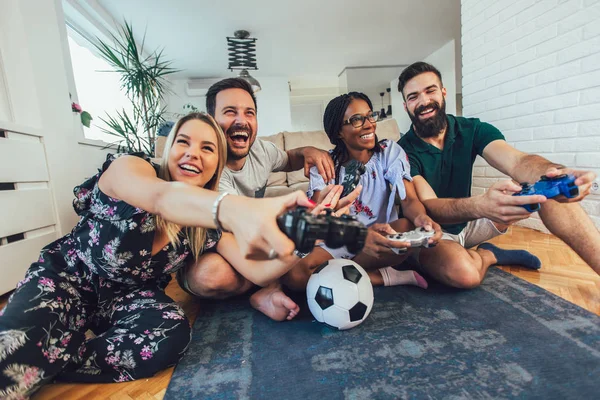 Felices amigos multiétnicos jugando videojuegos y divirtiéndose en h — Foto de Stock