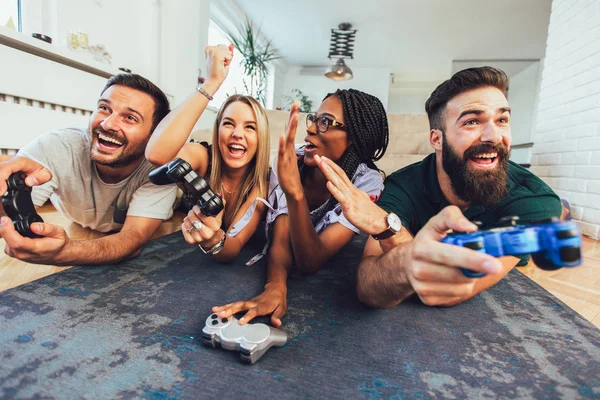 Amigos multiétnicos felizes jogando videogame e se divertindo em h — Fotografia de Stock