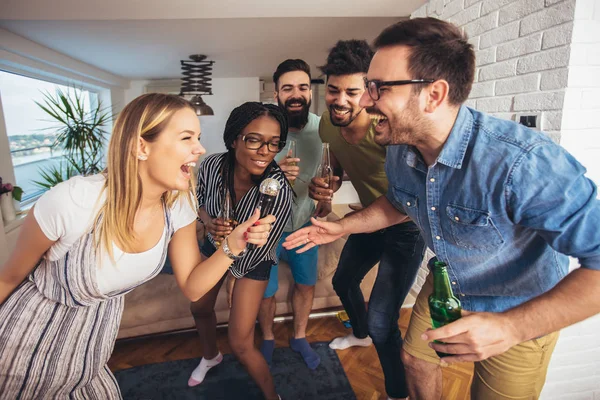 Glada vänner sjunger tillsammans hemma. Karaoke party konceptet — Stockfoto