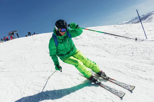 Esquiador esquiando cuesta abajo durante el día soleado en las altas montañas —  Fotos de Stock