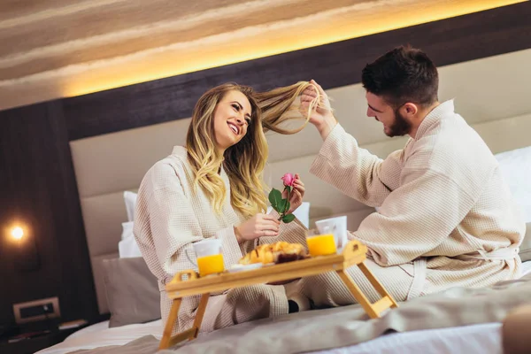 Giovane coppia felice fare colazione in camera d'albergo di lusso — Foto Stock