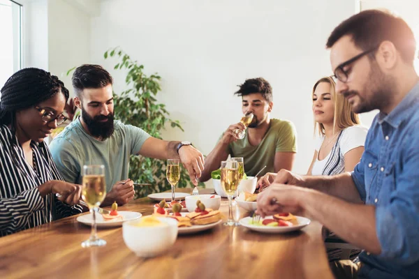 Abendessen mit Freunden. Gruppe fröhlicher junger Leute — Stockfoto