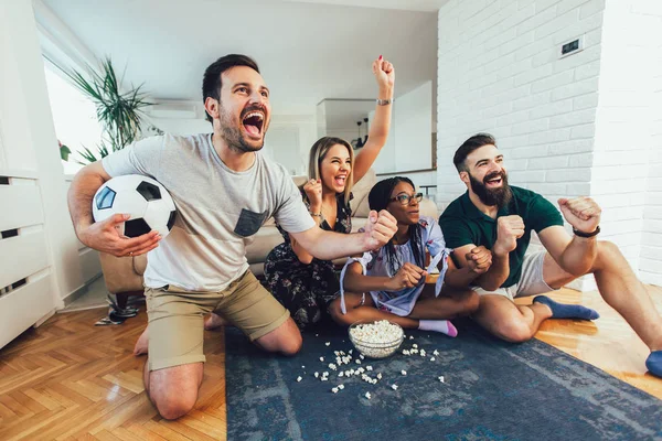 Bir grup neşeli arkadaş futbol maçı izleyip kutluyorlar. — Stok fotoğraf