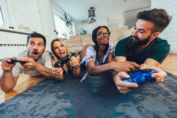 Grupo de amigos jogando videogames em casa . — Fotografia de Stock