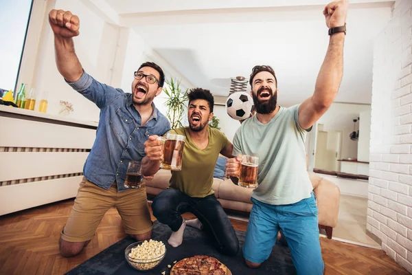 Glückliche Männerfreunde unterstützen Fußballmannschaft zu Hause — Stockfoto