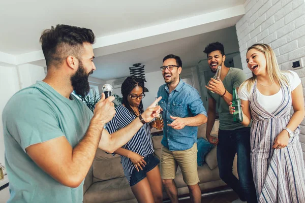 Happy vrienden thuis samenzang. Karaoke party concept — Stockfoto