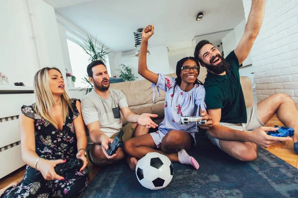 Grupo de amigos jugando videojuegos en casa . — Foto de Stock