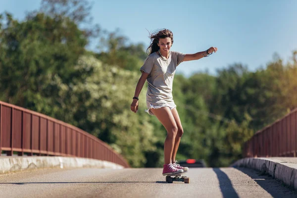 Sportieve vrouw rijdt op het skateboard op de weg. Longboarding, — Stockfoto
