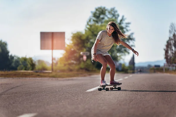 Sportieve vrouw rijdt op het skateboard op de weg. Longboarding, — Stockfoto