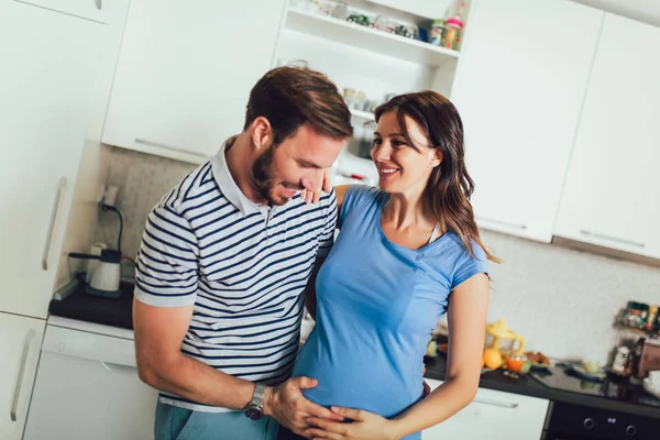 Pregnant woman with husband in the kitchen — Stock Photo, Image