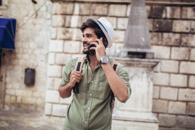 Sırt çantalı yakışıklı sakallı turist C boyunca seyahat ediyor.