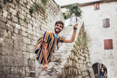 Sırt çantalı yakışıklı sakallı turist C boyunca seyahat ediyor.