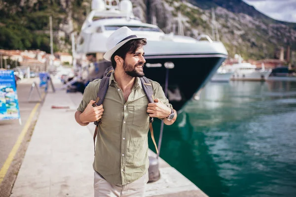 Giovane uomo a piedi dal porto di una località balneare turistica con b — Foto Stock