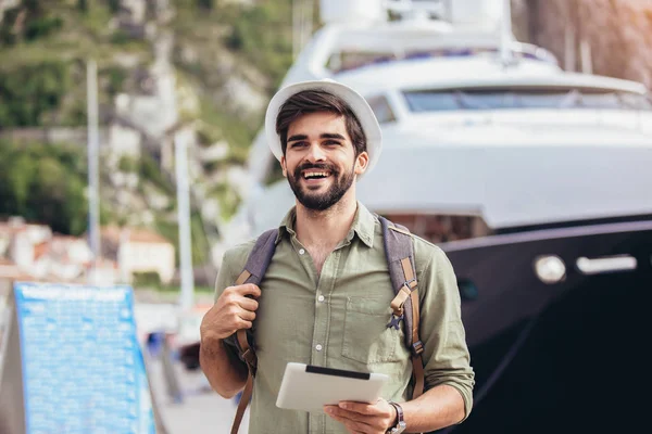 Giovane uomo a piedi dal porto di una località balneare turistica con b — Foto Stock