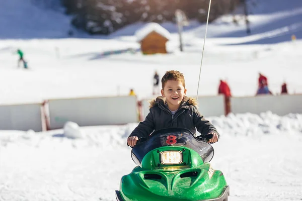 Chłopiec jazdy skuter śnieżny w zimowym krajobrazie — Zdjęcie stockowe