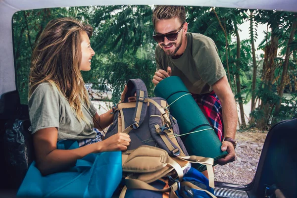 Tineri cuplu având distracție în timp ce despachetarea echipamentelor de camping — Fotografie, imagine de stoc