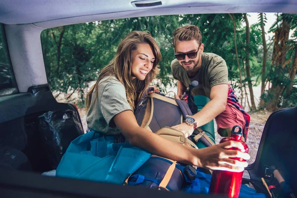 Ungt par har det sjovt, mens udpakning camping udstyr - Stock-foto