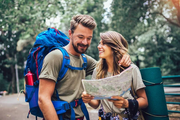 Усміхнена пара ходить з рюкзаками на природному тлі — стокове фото