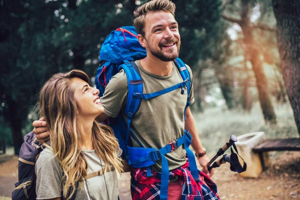 Sorrindo casal andando com mochilas sobre fundo natural — Fotografia de Stock