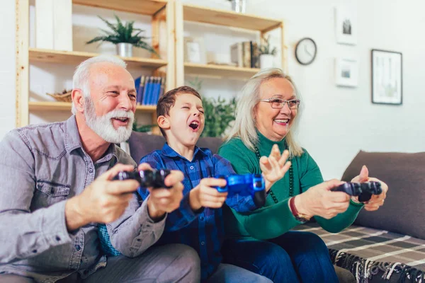 Senior homme et femme jouer à des jeux vidéo tandis que leur grand — Photo