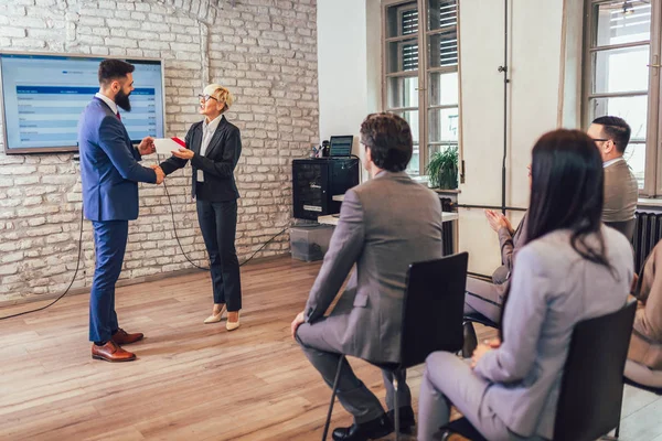 Front view of businessman receiving award from businesswoman in — Stock Photo, Image