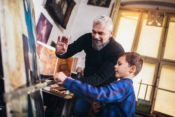 Ojciec i syn pracują i malują razem w pracowni artystycznej — Zdjęcie stockowe