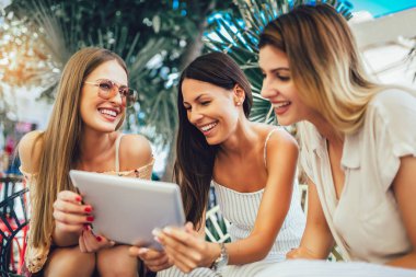 Dijital tablet ve havin kullanarak bir kafede üç güzel arkadaş