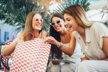 Bir kafede alışveriş yapan üç genç kadın.