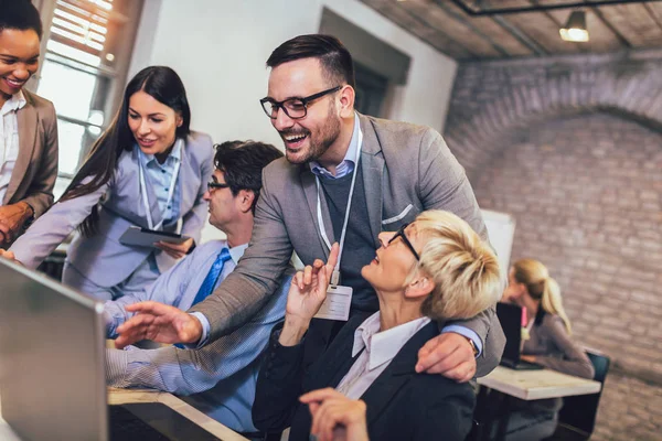 Smiling young manager helping senior worker with computer work i — Stock Photo, Image