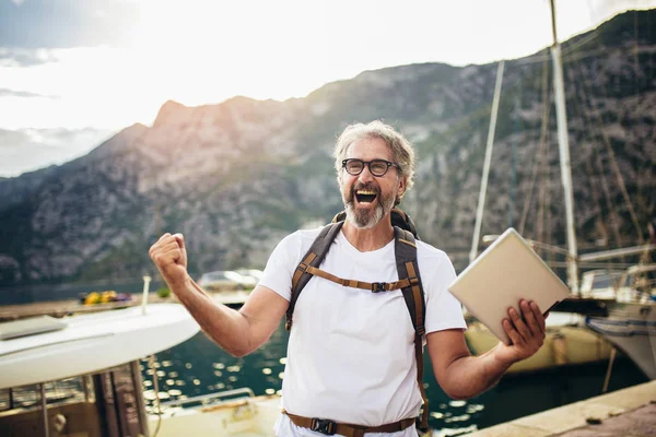 Souriant touriste mature homme debout avec tablette numérique et le dos — Photo