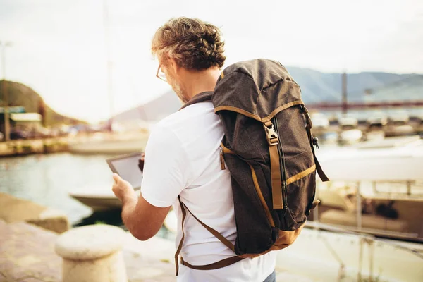 Sorrindo turista maduro homem de pé com tablet digital e costas — Fotografia de Stock