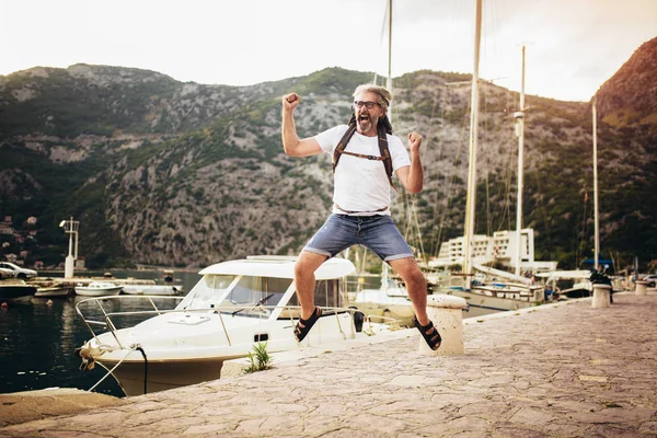 Sorrindo turista maduro homem se divertindo perto do mar . — Fotografia de Stock