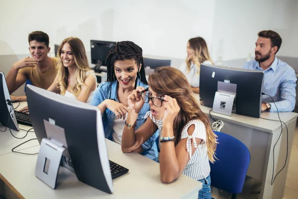 Estudantes universitários sentados em uma sala de aula, usando computadores durante — Fotografia de Stock