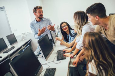 Üniversite öğrencileri bir sınıfta otururken, bilgisayar ları 