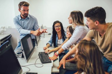 Üniversite öğrencileri bir sınıfta otururken, bilgisayar ları 