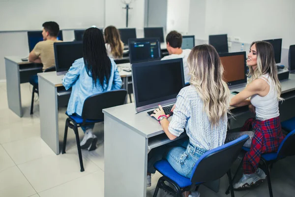 Estudantes universitários sentados em uma sala de aula, usando computadores durante — Fotografia de Stock