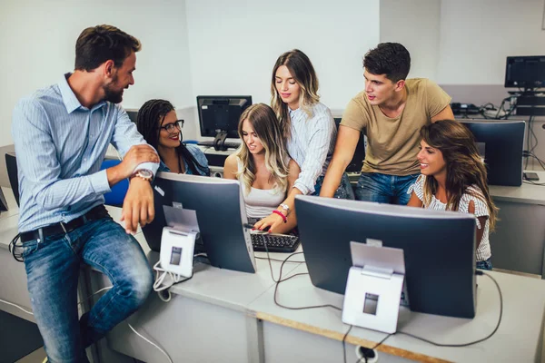 Estudantes universitários sentados em uma sala de aula, usando computadores durante — Fotografia de Stock