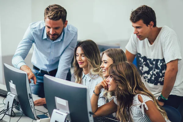 Högskolestudenter som sitter i ett klassrum och använder datorer — Stockfoto