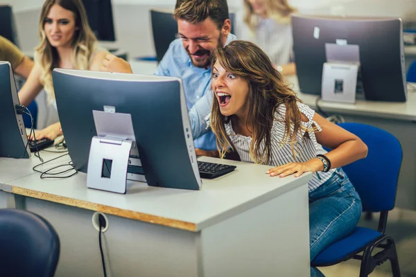 Estudantes universitários sentados em uma sala de aula, usando computadores durante — Fotografia de Stock