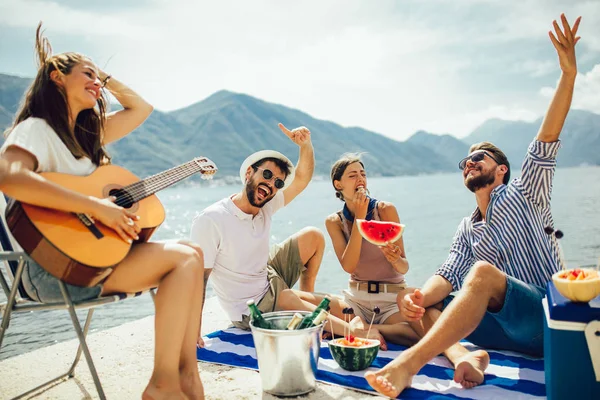 Gelukkige jonge mensen hebben plezier op het strand partij. — Stockfoto